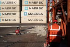 Worker is seen next to Maersk shipping containers at a logistics center near Tianjin por